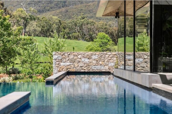Photo of a beautiful outdoor pool with mountains in the background.